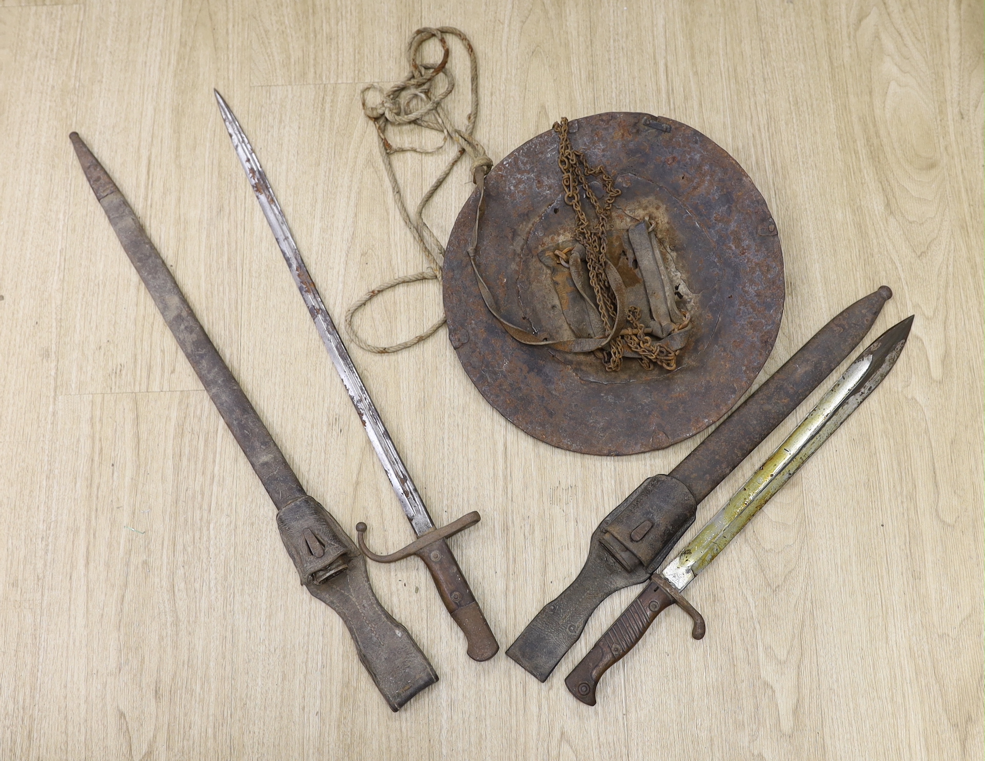 A 19th century iron shield, North African? and a WWI German bayonet and an Ottoman bayonet, shield 34cm